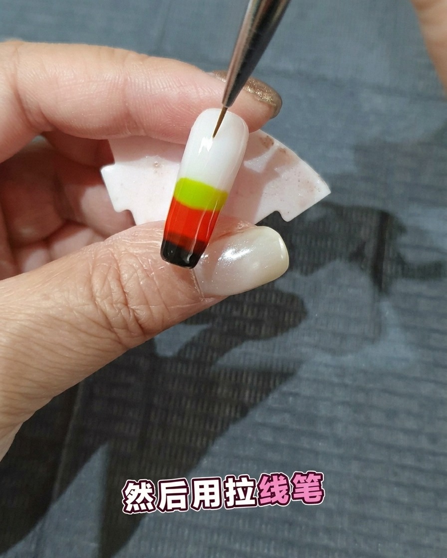 Un pennello per nail art sottile traccia delle linee attraverso gli strati di gel colorato umido per creare un motivo a fiamma.