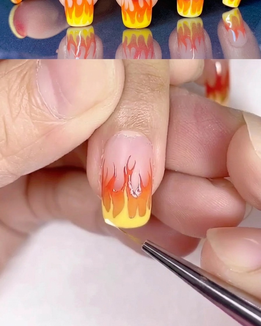 Nail art a fiamme dettagliata con laggiunta di punti luce in giallo chiaro.