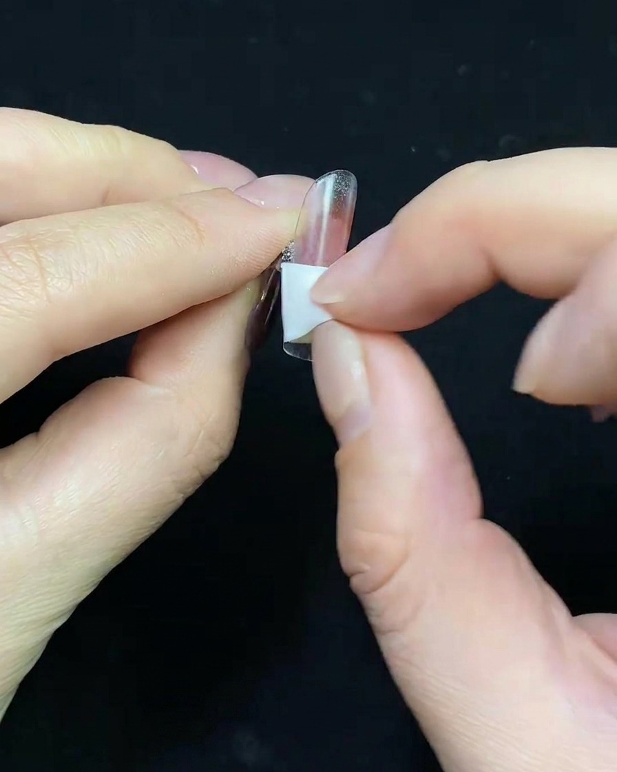Un primo piano dellapplicazione di una base gel color nude su una tip trasparente.