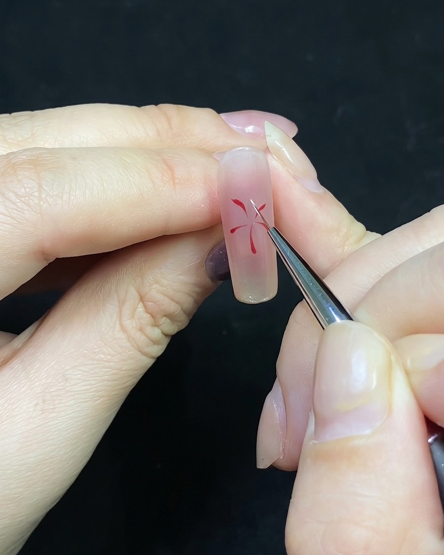 Un pennello di precisione che aggiunge linee bianche tra quelle rosse in un design a fuochi dartificio.