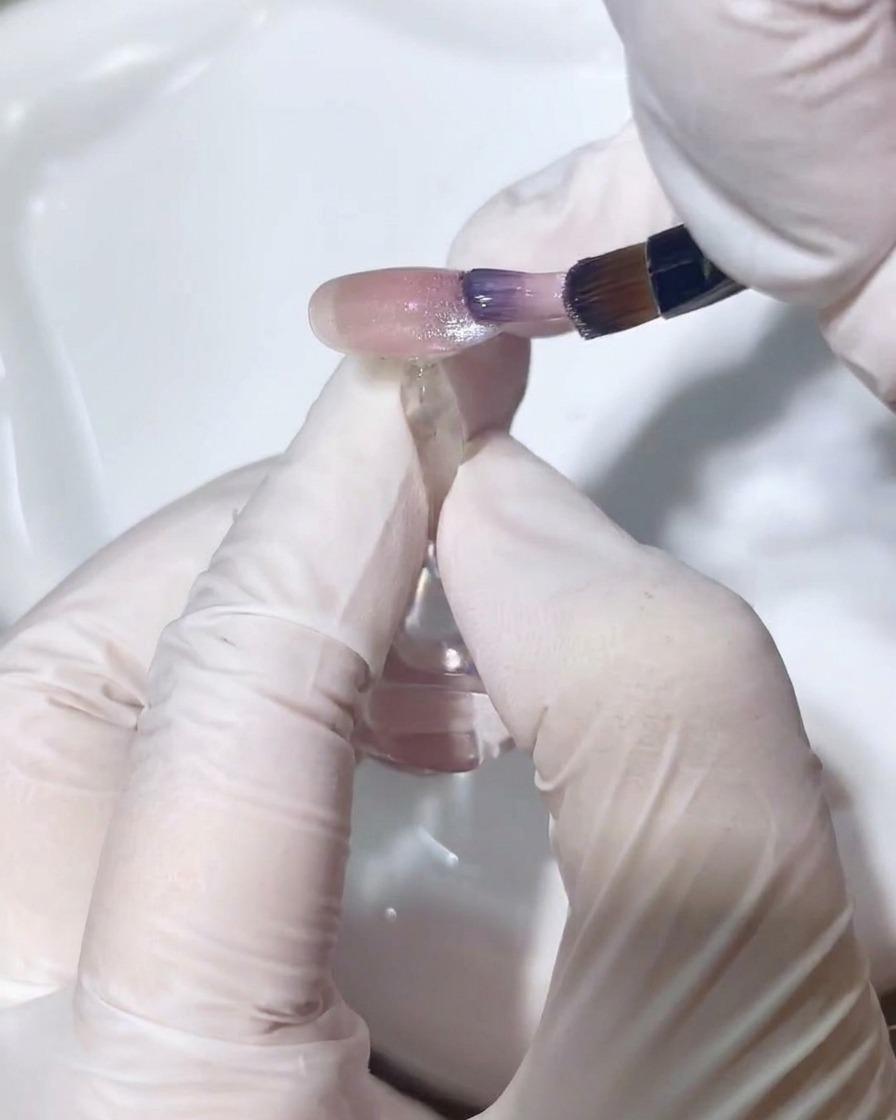 Un pennello a punta sottile sfuma delicatamente lo smalto cat-eye per creare un passaggio graduale.