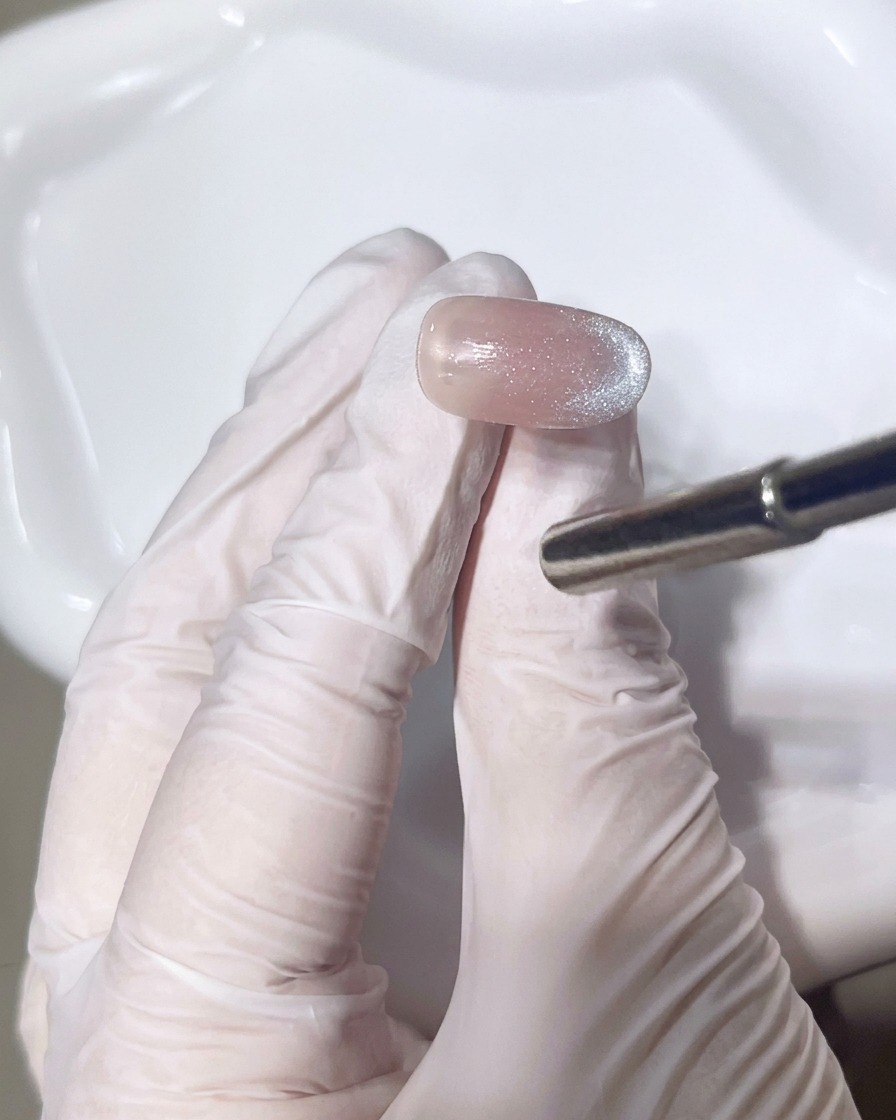 Primo piano di un pennello che applica un secondo strato di gel scintillante per perfezionare la sfumatura.