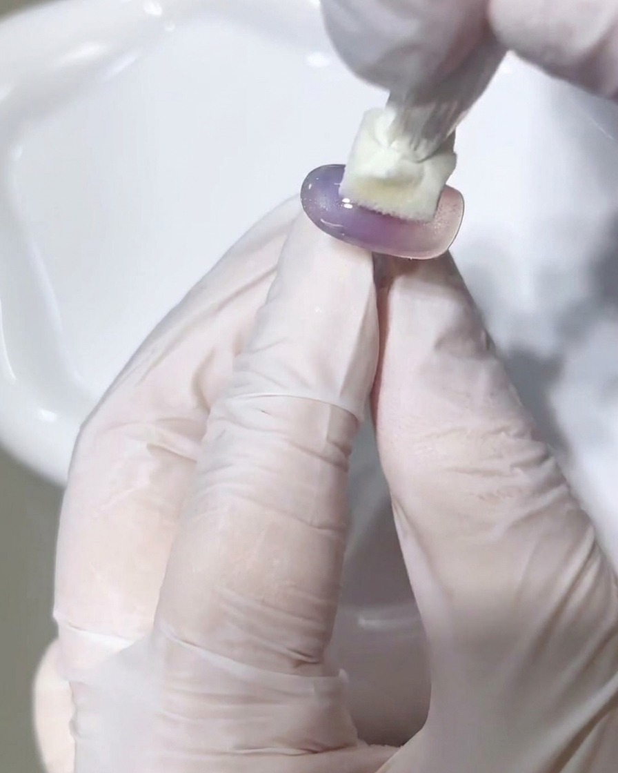 Un panno senza pelucchi viene utilizzato per pulire la superficie di una tip gel polimerizzata.