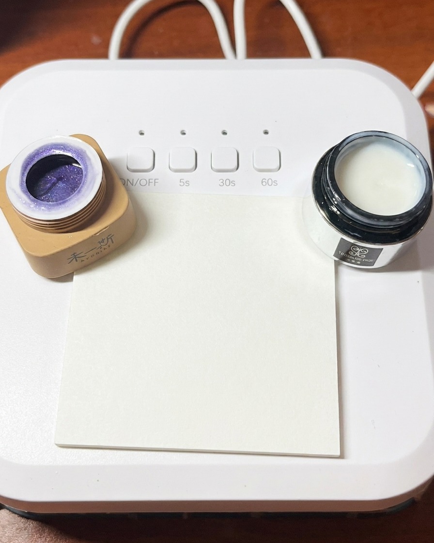 Un pennello liner sottile che posiziona delicatamente piccoli glitter e scaglie di opale tra i frammenti di conchiglia.