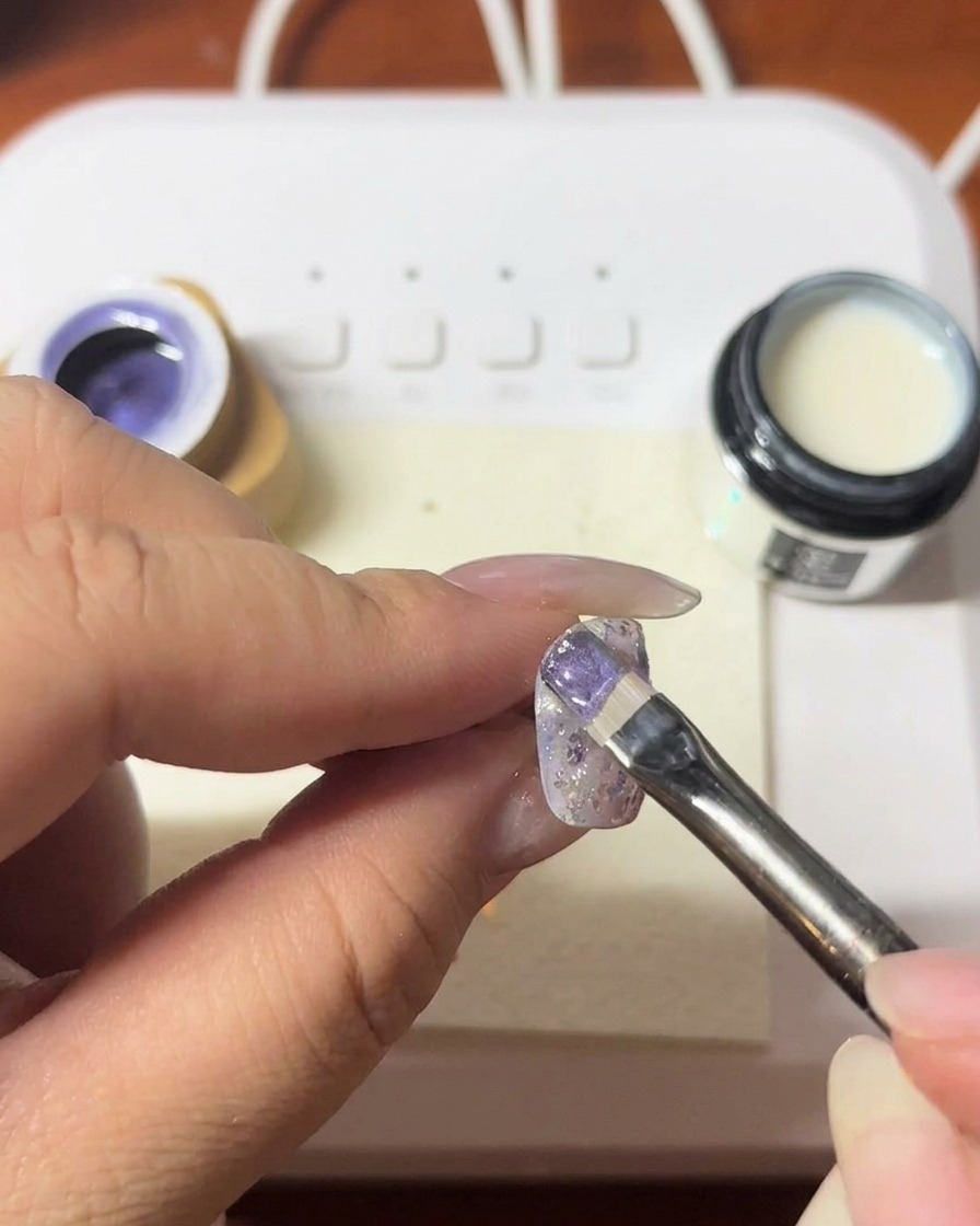 Uno strumento magnetico tenuto vicino allunghia per creare una linea cat-eye scintillante nel gel viola.