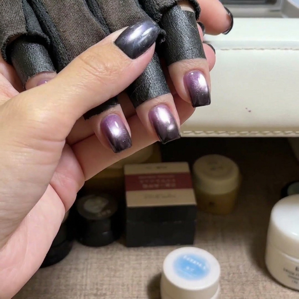 Un pennello che applica smalto gel cat eye blu su ununghia naturale.