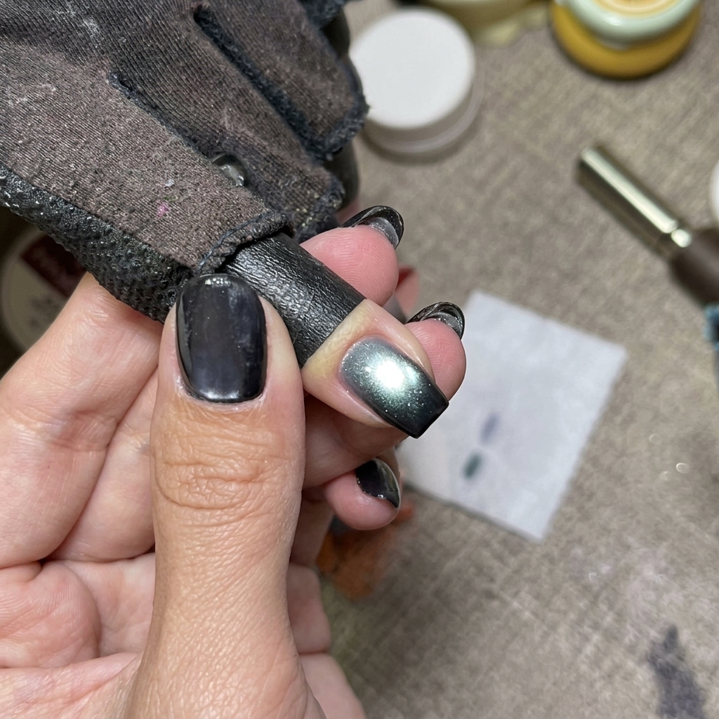 Unghie cat eye blu che polimerizzano sotto una lampada UV.