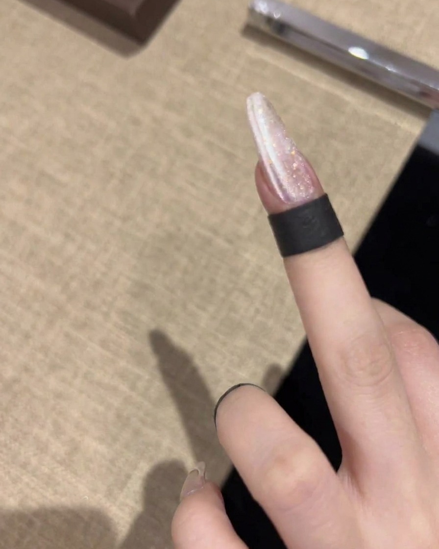 Un magnete tenuto in posizione orizzontale vicino allunghia, creando una linea netta e luminosa sullo smalto gel cangiante.