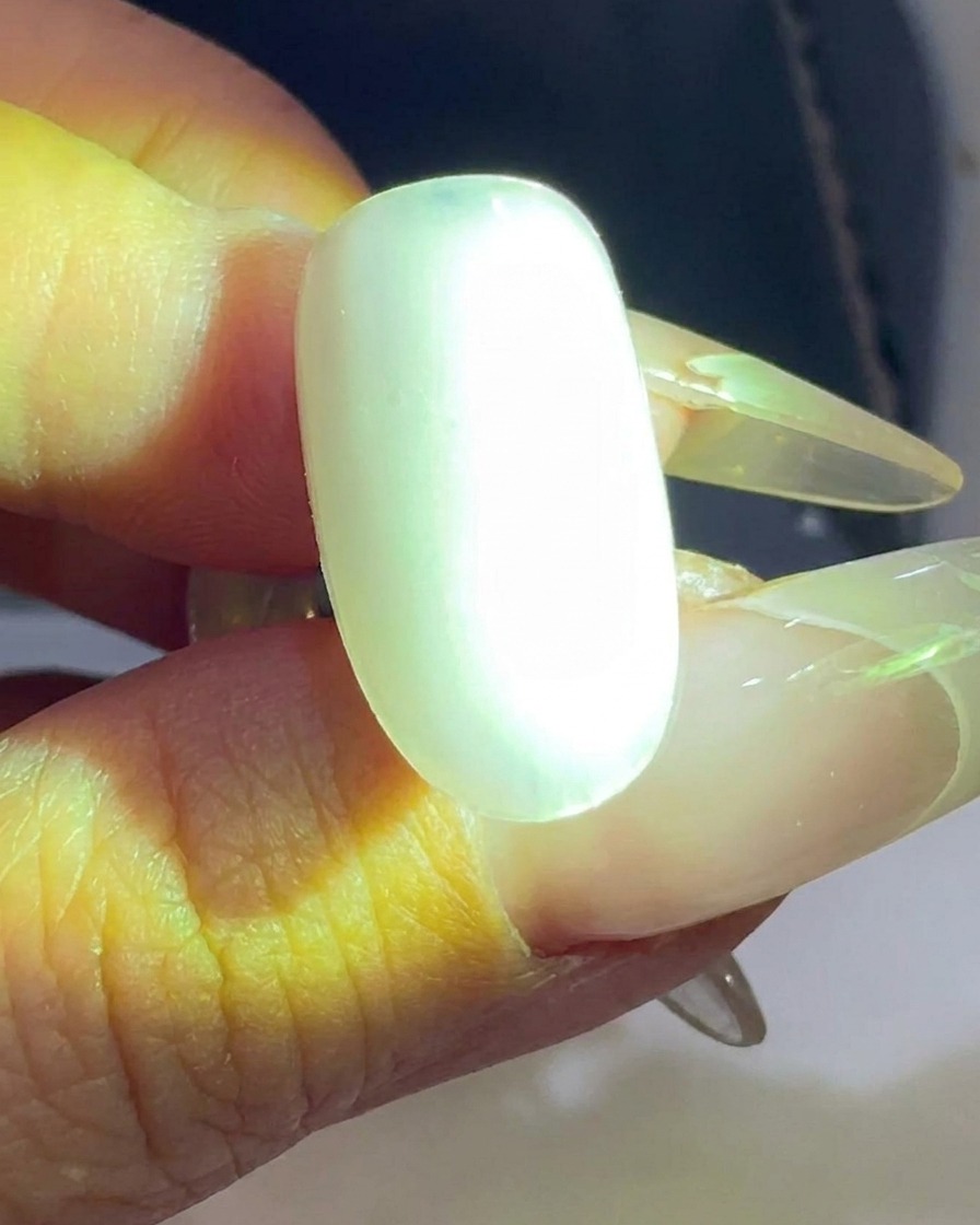 Una tip trasparente viene polimerizzata sotto una lampada UV/LED per unghie.