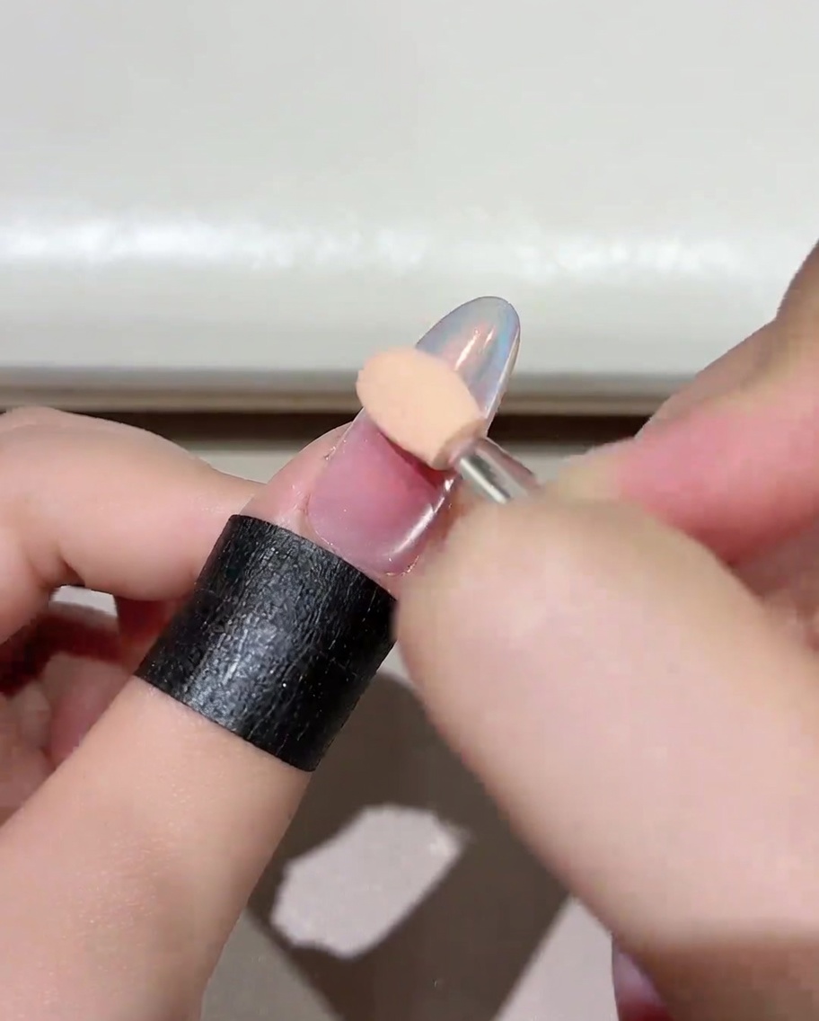 Primo piano di ununghia in cura allinterno di una lampada UV/LED professionale per unghie, che mostra il processo di polimerizzazione.