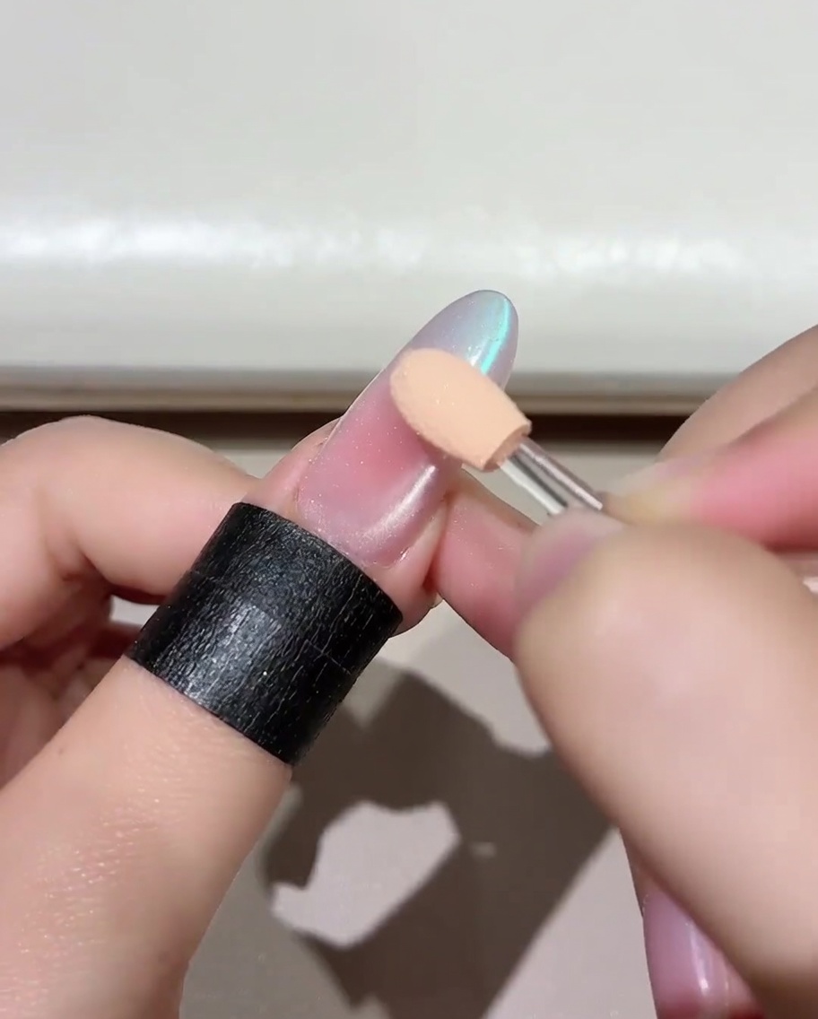 Un pennello che applica uno strato vibrante di smalto gel Jade D05 su ununghia preparata.