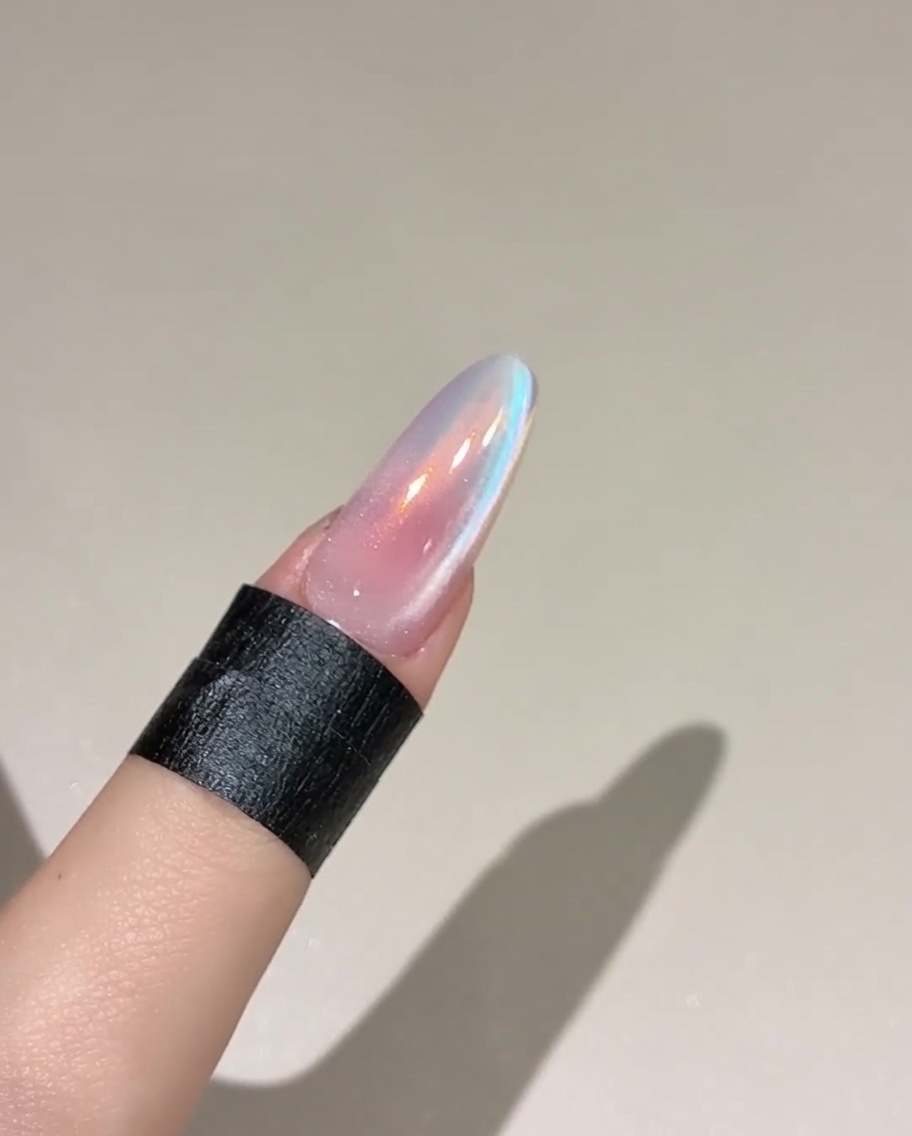 Un pennello che applica uno strato di top gel su ununghia rosa polimerizzata.