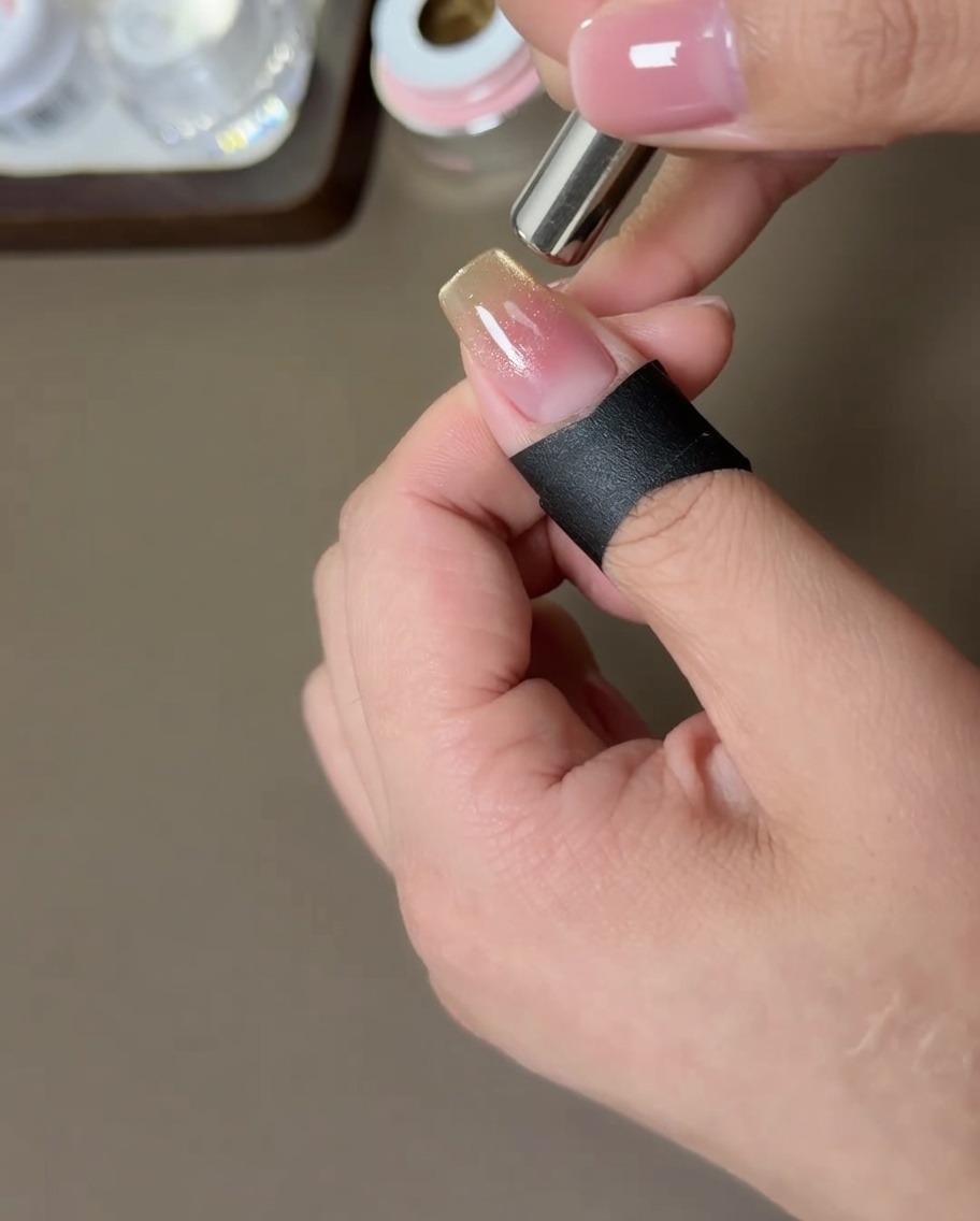 Un magnete cilindrico posizionato ai lati dellunghia per muovere le particelle magnetiche dorate.
