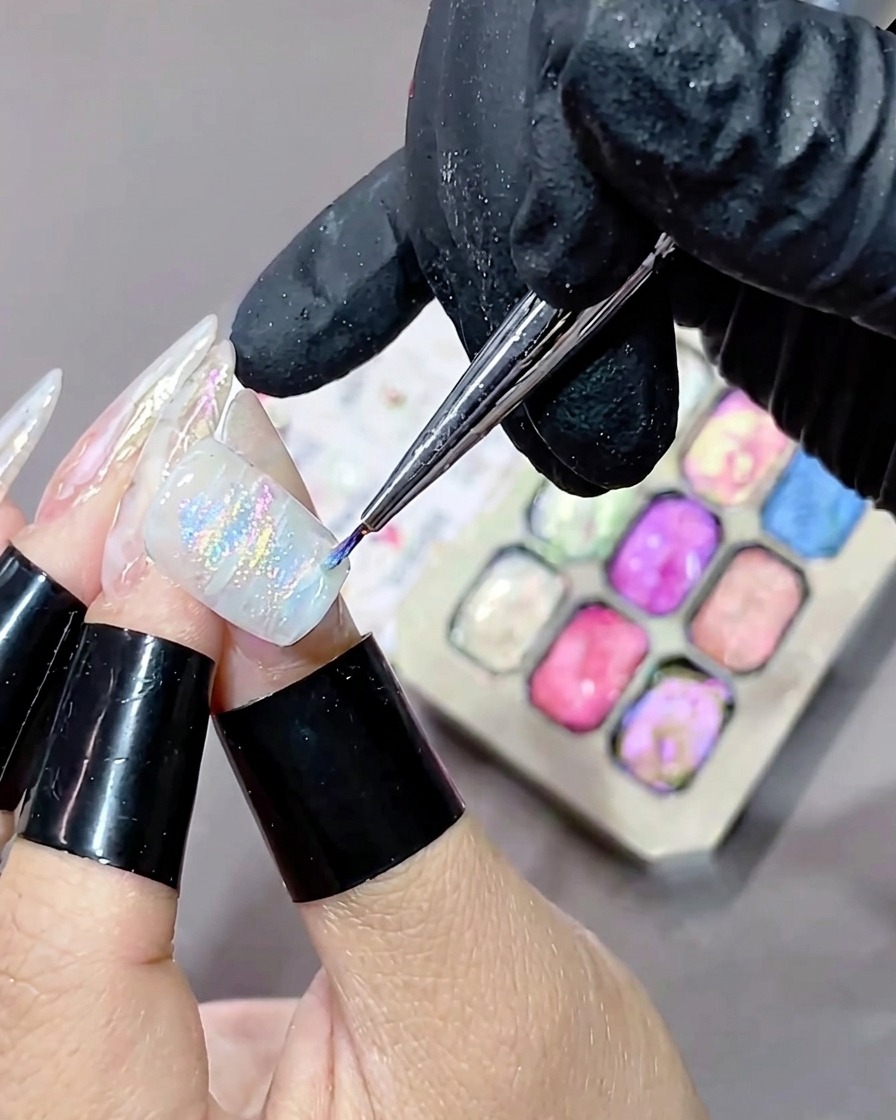 Ununghia con un design in gel marmorizzato appena applicato che viene inserita in una lampada polimerizzante UV.