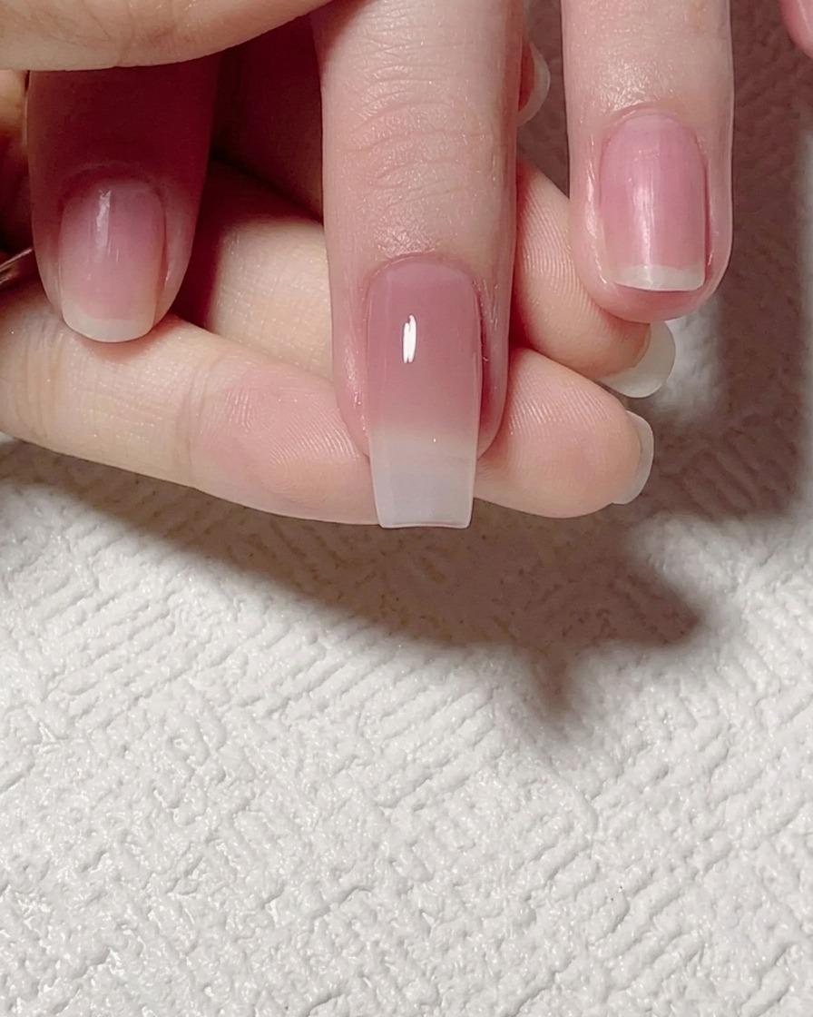 Un pennello piatto che sfuma il gel color giada verso lalto per creare una transizione morbida sullunghia.