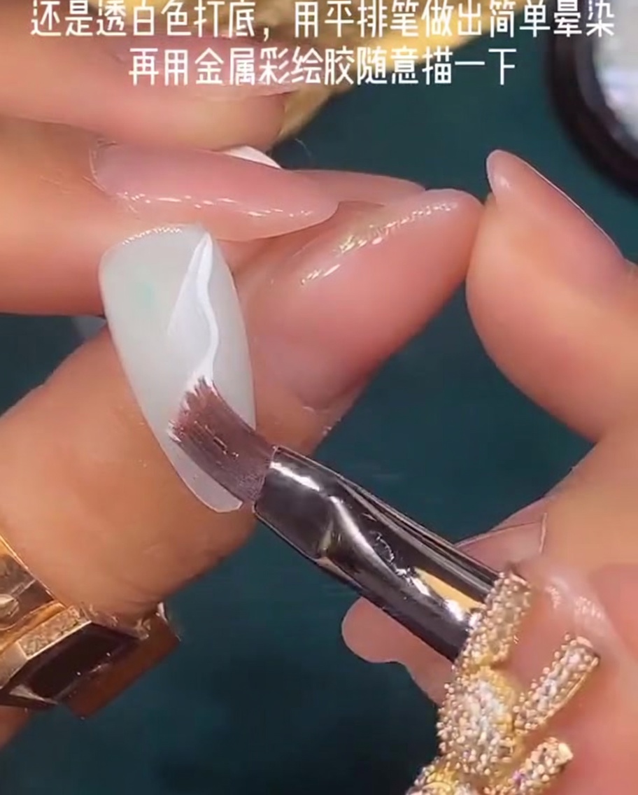 Un pennello piatto utilizzato per sfumare lo smalto gel bianco ancora umido sulla superficie dellunghia.