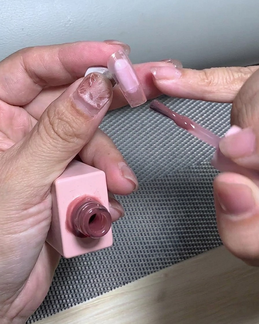 Un pennello che sfuma i glitter sulla punta dellunghia per creare un effetto gradiente.