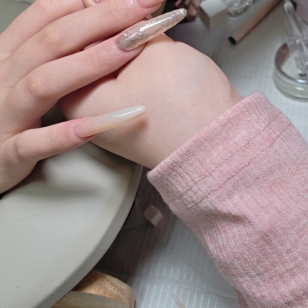 Un pennello liner che applica con cura un velo di builder gel trasparente attorno ai bordi di un gruppo di strass.