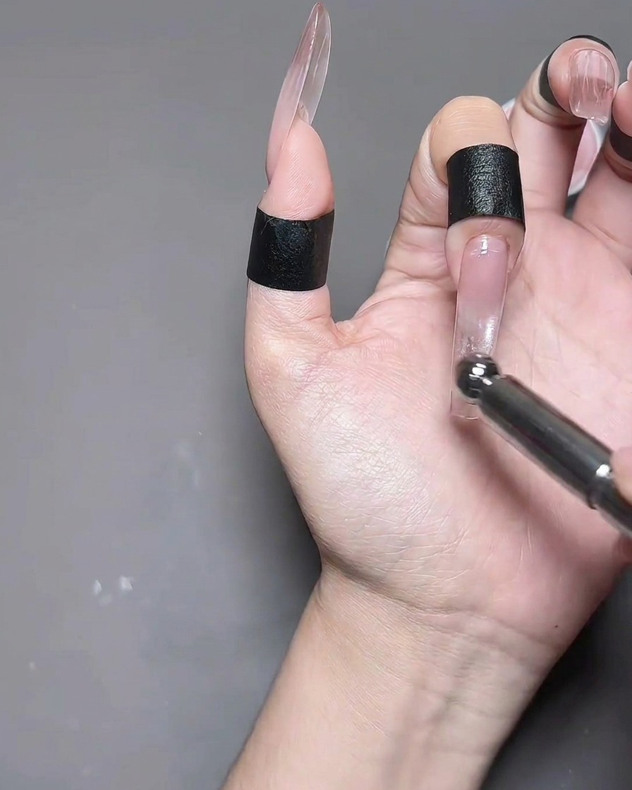 Una mano con unghie in gel cat eye posizionata allinterno di una lampada professionale per la polimerizzazione.