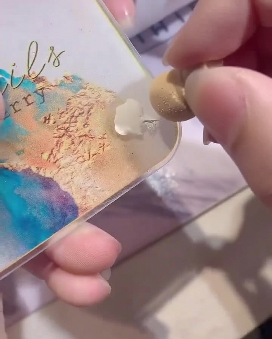Uno scatto ravvicinato che mostra una spugnetta da trucco bianca caricata con smalto gel bianco da una tavolozza.