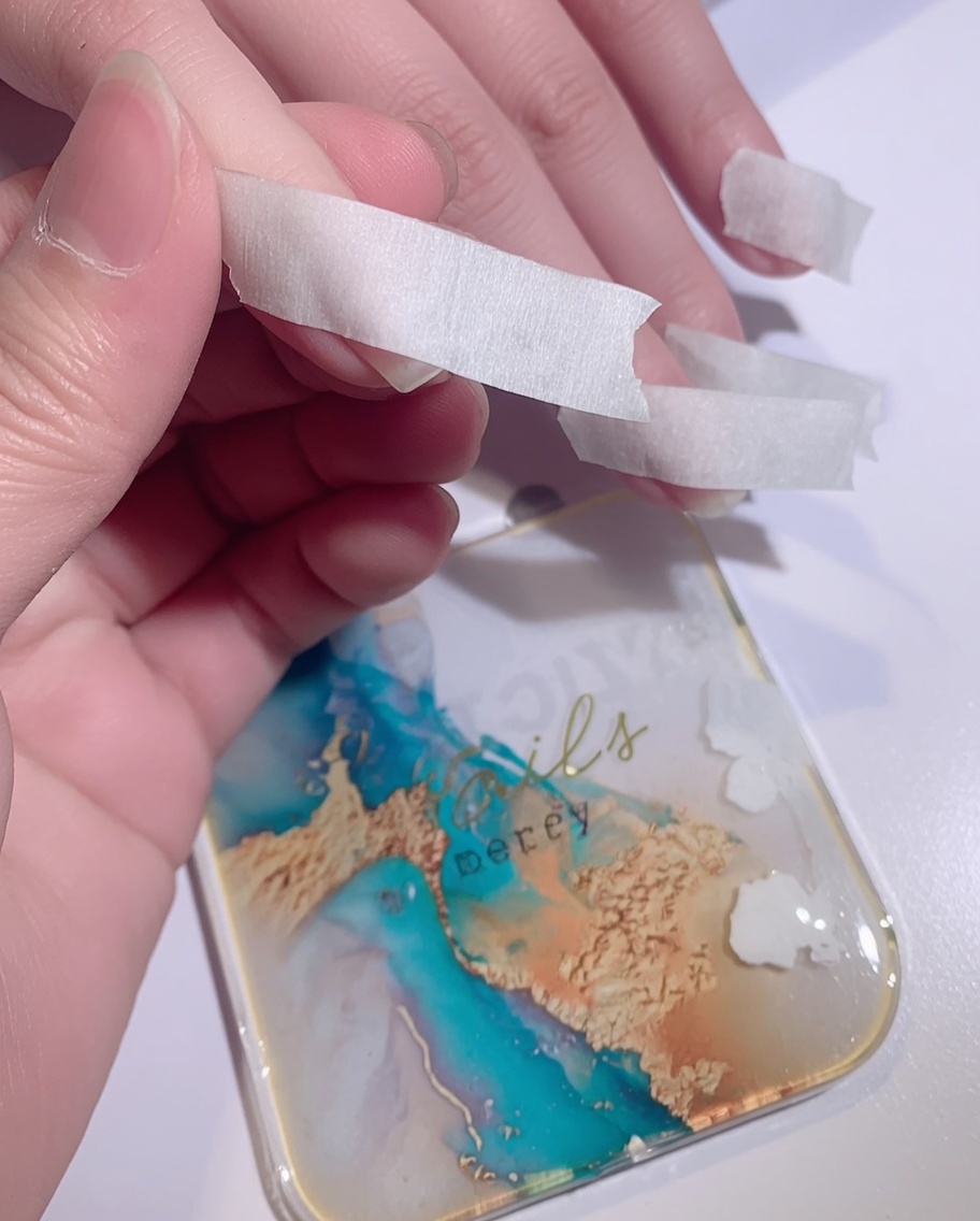 Una spugnetta che tampona smalto gel bianco sulla punta di ununghia per creare un effetto ombré.