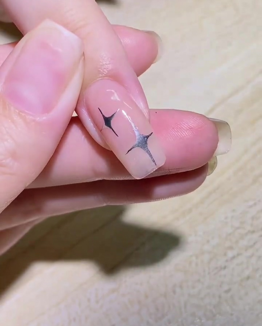 Un pennello liner che disegna il contorno curvo di unala di farfalla sul lato di ununghia.