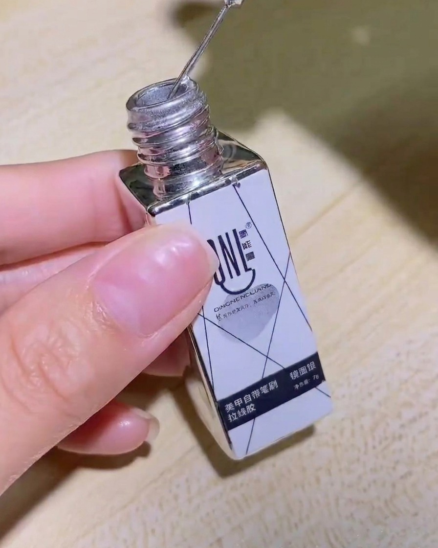 Una mano che tiene il flacone di gel liner a specchio argentato, mostrando chiaramente letichetta del prodotto.