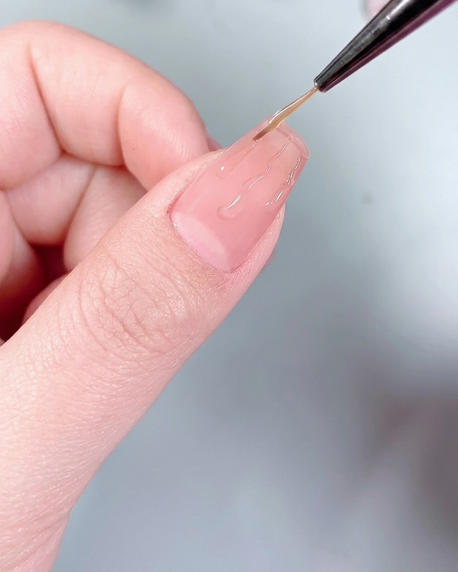 Un applicatore in silicone che pressa la polvere cromata argentata sulle linee di colla a forma di fiamma sullunghia.