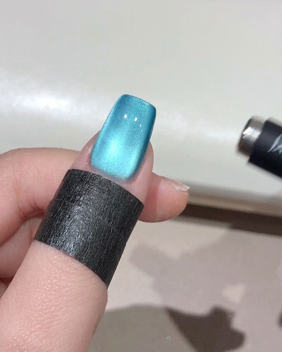 Magnete sferico tenuto vicino al bordo dellunghia per concentrare i riflessi in una perla 3D.