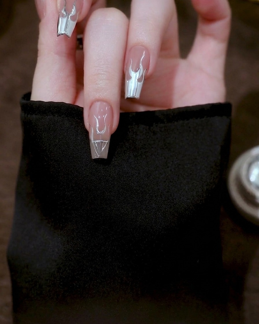 Primo piano che mostra lunghe linee curve in gel argento che si estendono dalla base della fiamma fino al bordo dellunghia.
