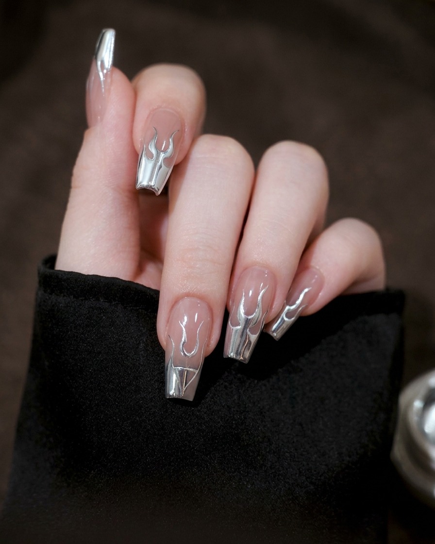 Primo piano di ununghia in cui le linee in gel argento vengono collegate per formare una silhouette di fiamma completa.