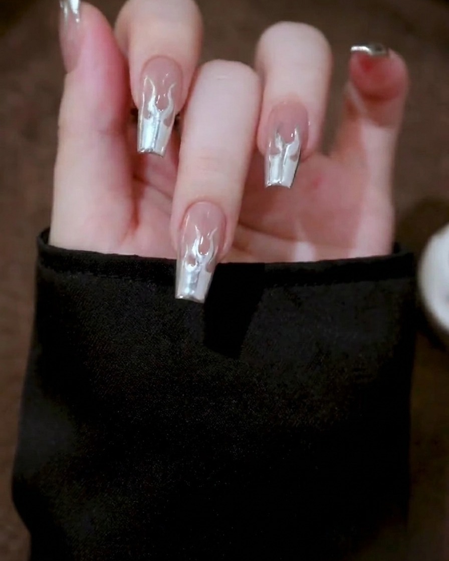 Primo piano di una mano posta allinterno di una lampada professionale per unghie, con il design in gel metallizzato che subisce il processo di polimerizzazione.