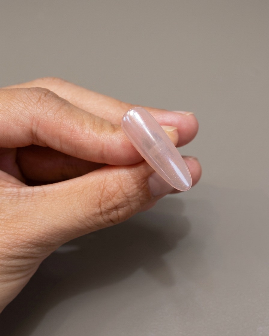 Un pennello applica uno strato protettivo di gel trasparente sopra ununghia con finitura cromo a specchio.