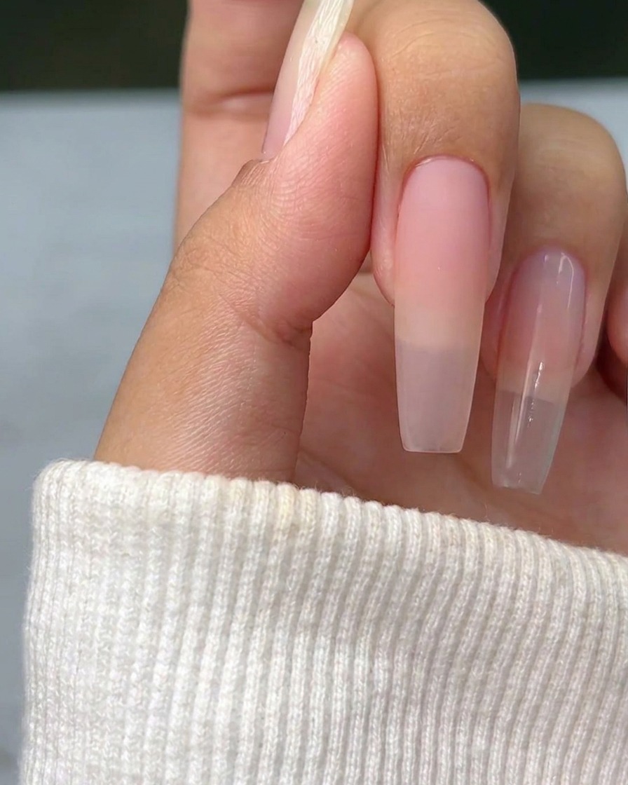 Una sottile croce in argento metallizzato dipinta su una superficie ungueale naturale, che funge da guida per la nail art successiva.