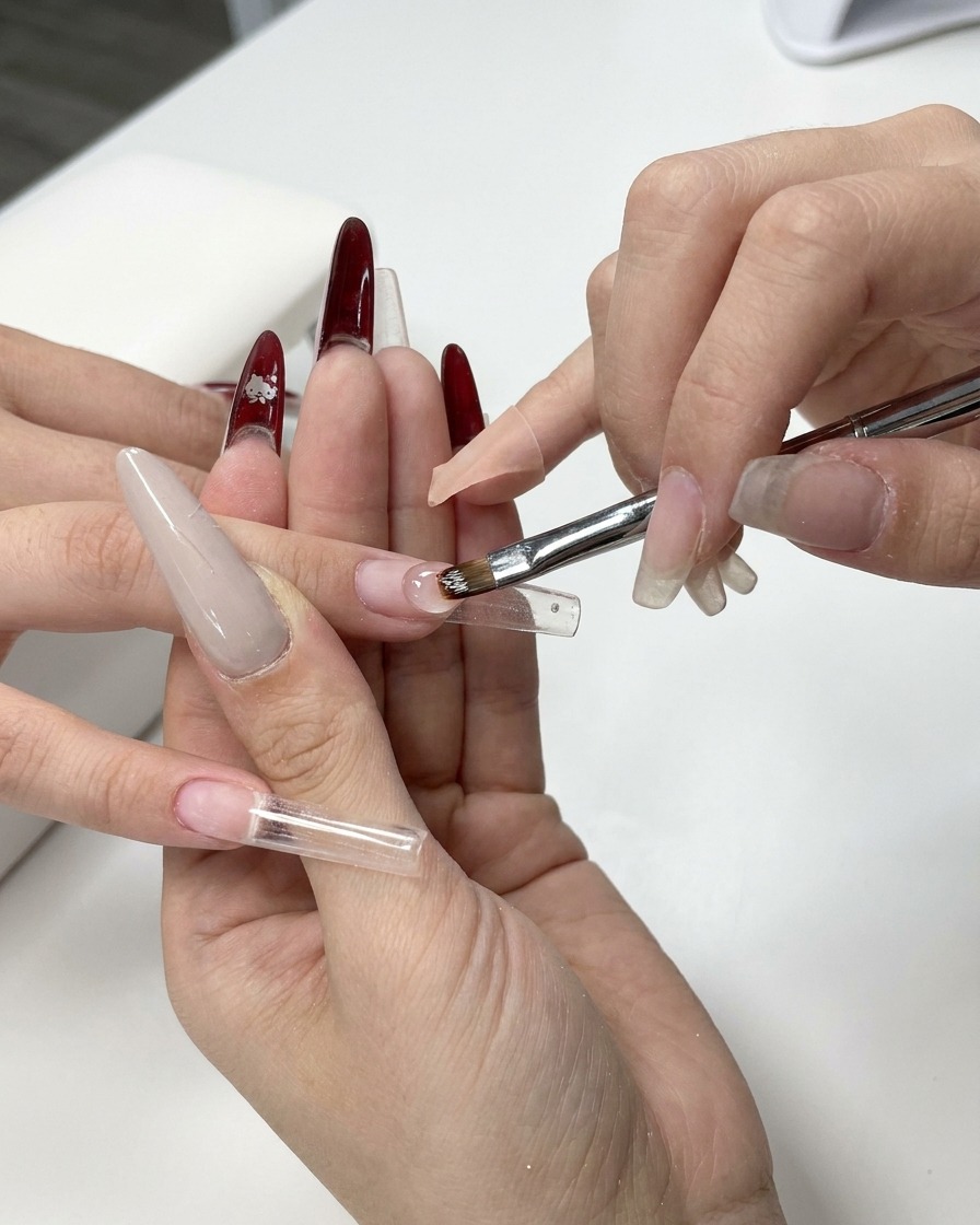 Primo piano di un pennello per gel che applica il gel costruttore trasparente su una cartina.