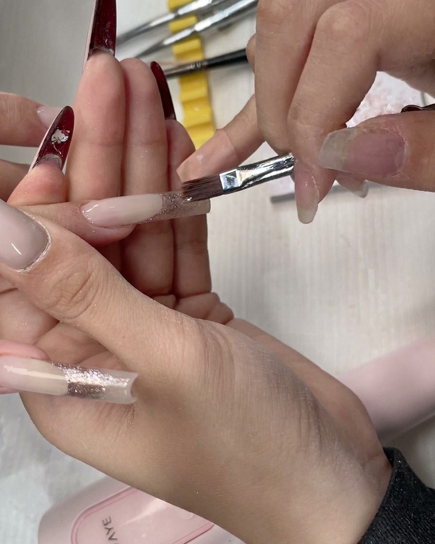 Un pennello piatto che esegue i tratti di sfumatura finali per una transizione morbida dei glitter.