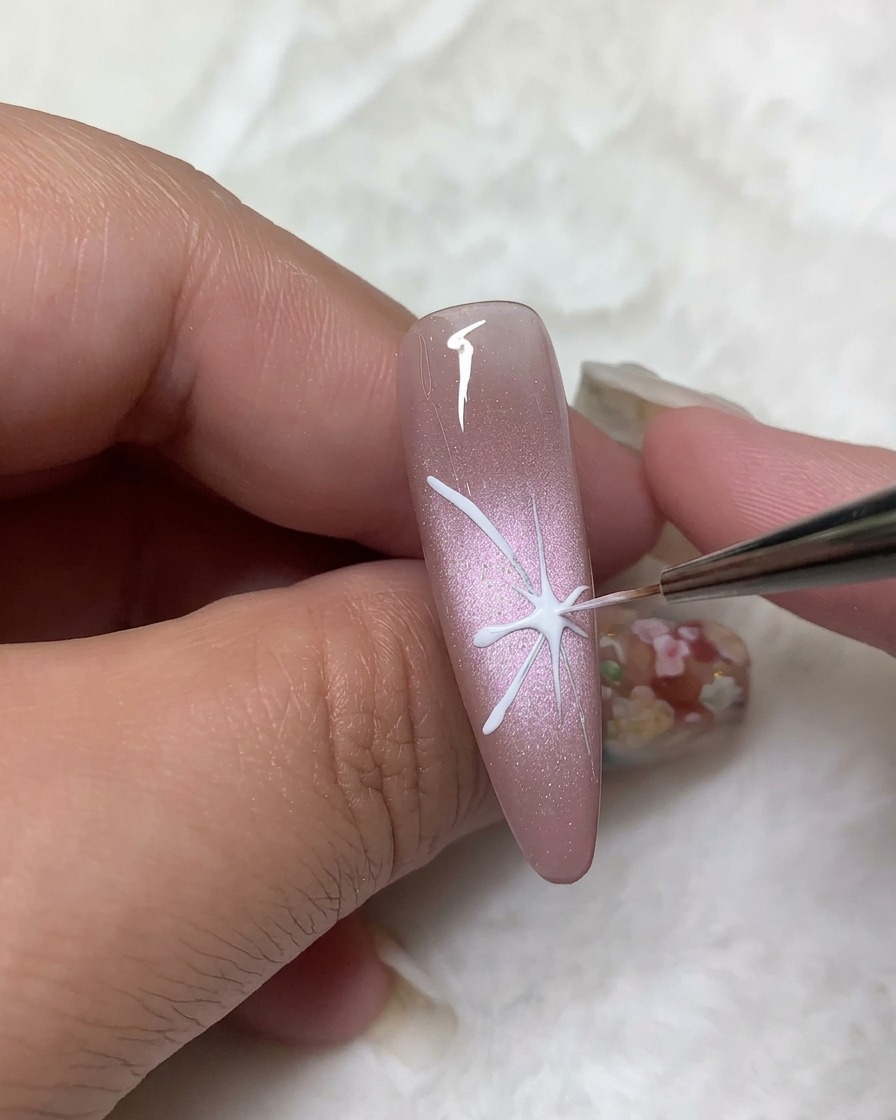 Un pennello di precisione che riempie i contorni superiori delle ali della farfalla con smalto gel bianco coprente.