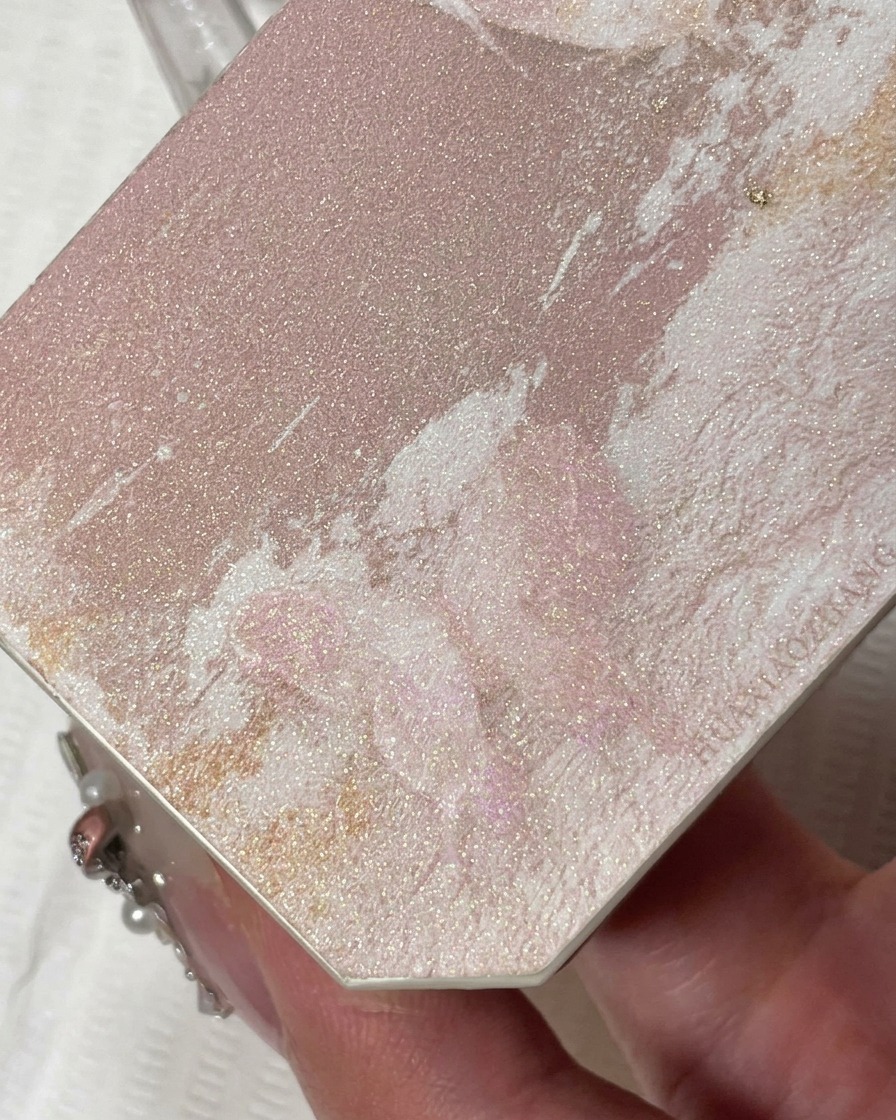 Primo piano di un pennello liner sottile che applica gel glitter color champagne sulla punta dellunghia.
