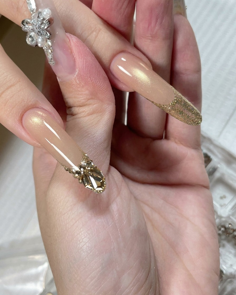 Uno strumento di precisione che deposita una piccola goccia di gel adesivo trasparente sulla superficie dellunghia alla base del glitter.