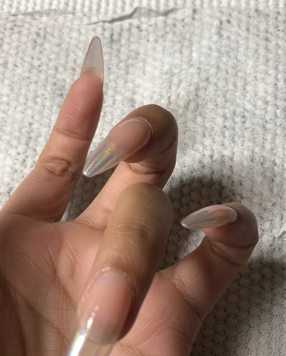Una mano che usa un piccolo buffer per limare il bordo anteriore di ununghia.