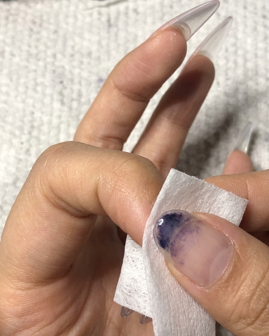Una salvietta senza pelucchi utilizzata per pulire la superficie di un anulare curato.