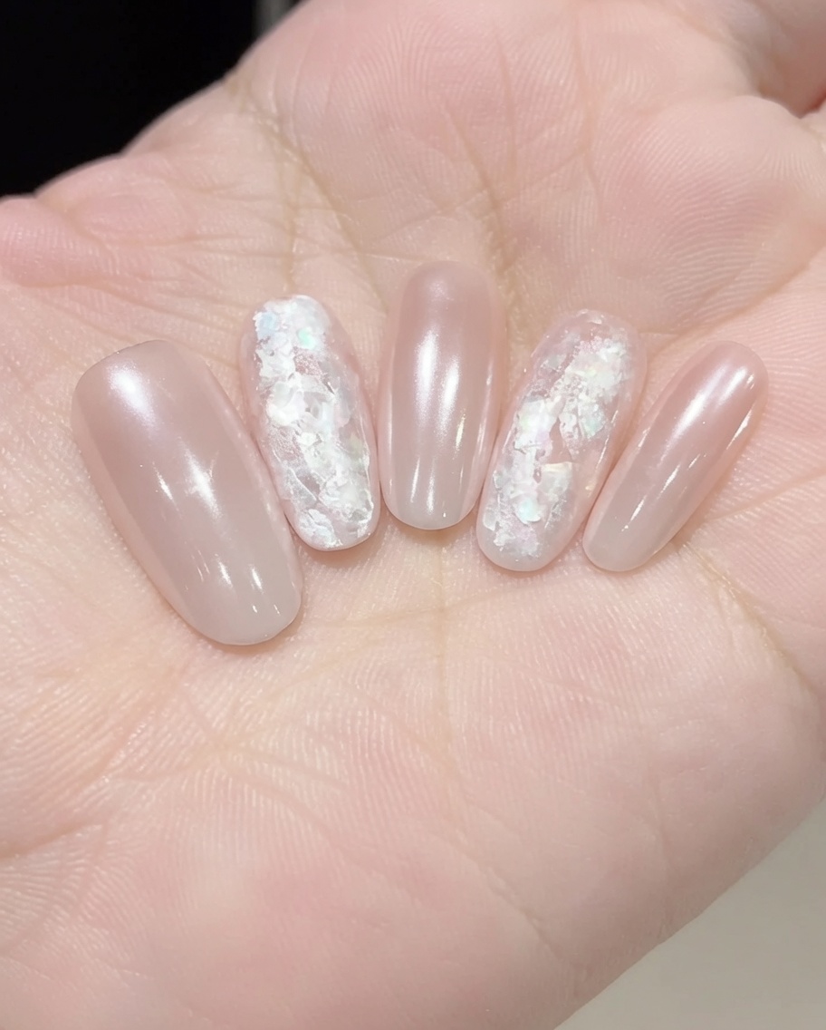Applicazione di un gel rinforzante trasparente sopra la nail art incastonata per levigare e sigillare.