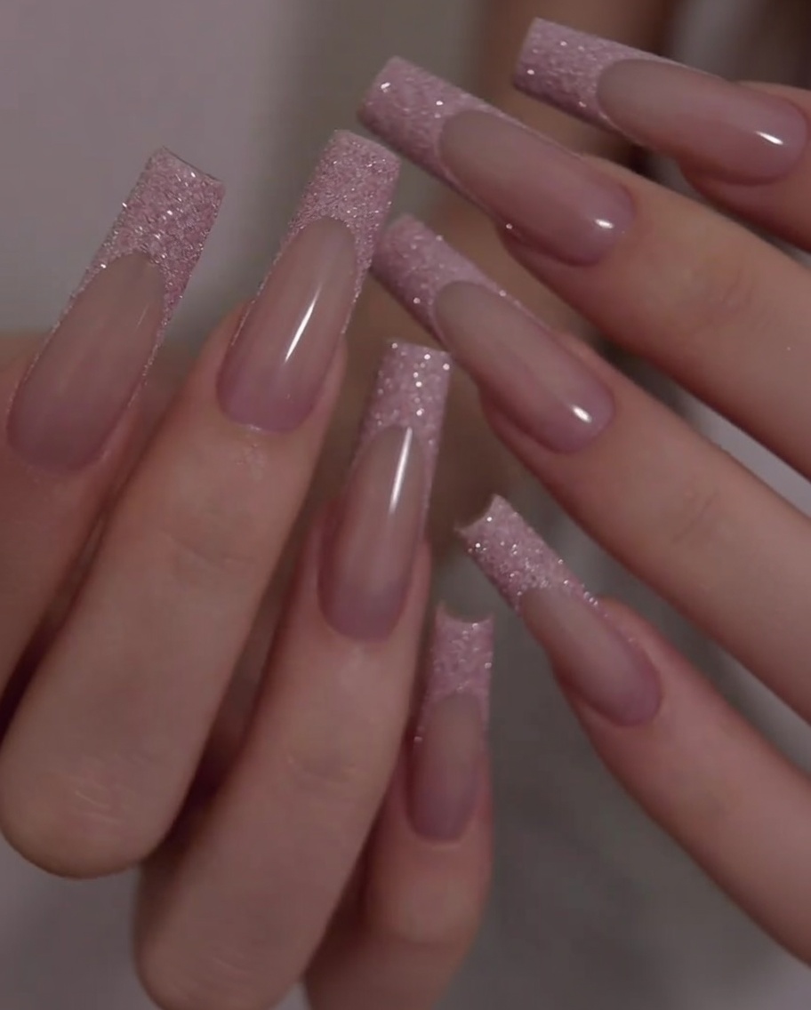 Un primo piano che mostra la transizione fluida e la superficie uniforme tra la base rosa e la punta glitterata durante un leggero movimento della mano.