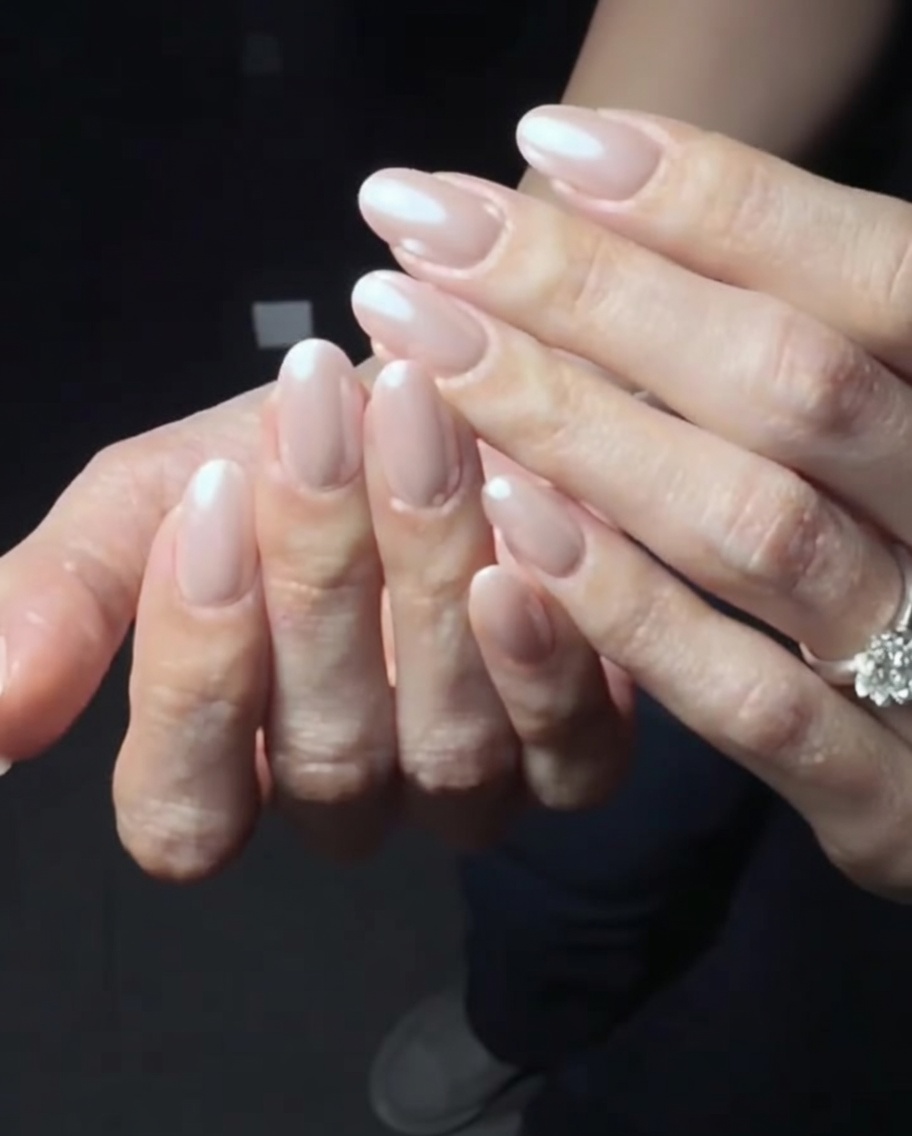 Primo piano delle mani che lucidano la superficie delle unghie con polvere chrome per rifinire il look.