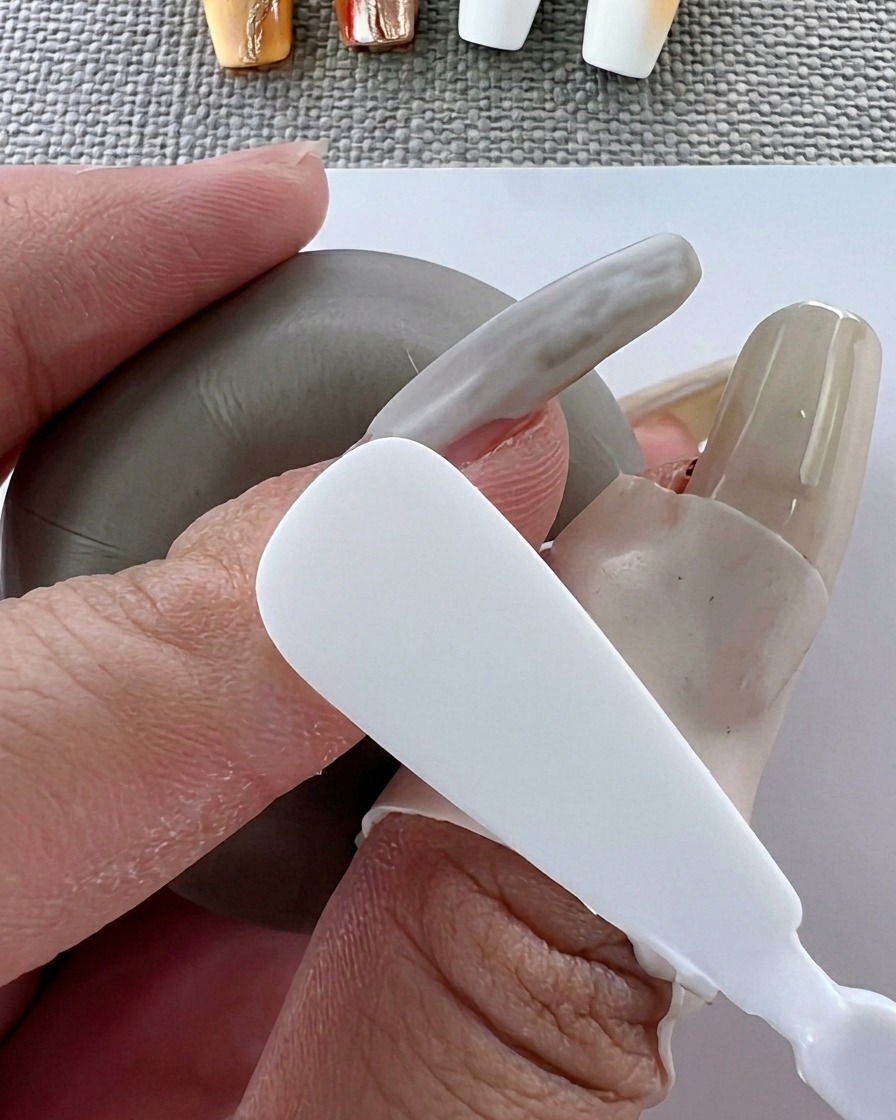 Un pennello applica uno strato uniforme di smalto gel bianco sulla superficie dellunghia.