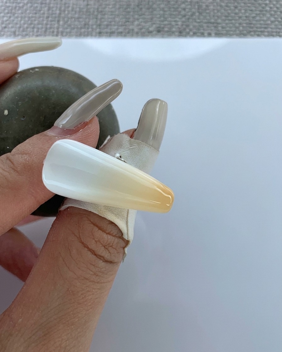 Un pennello applica un top coat trasparente sopra la sfumatura appena realizzata.