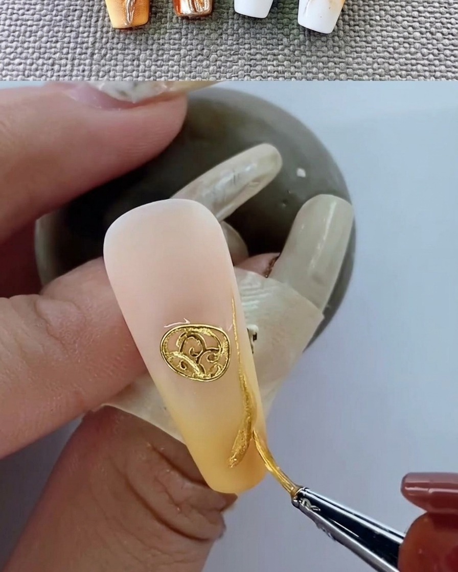Ununghia curata con un emblema metallico durante la polimerizzazione sotto lampada UV.