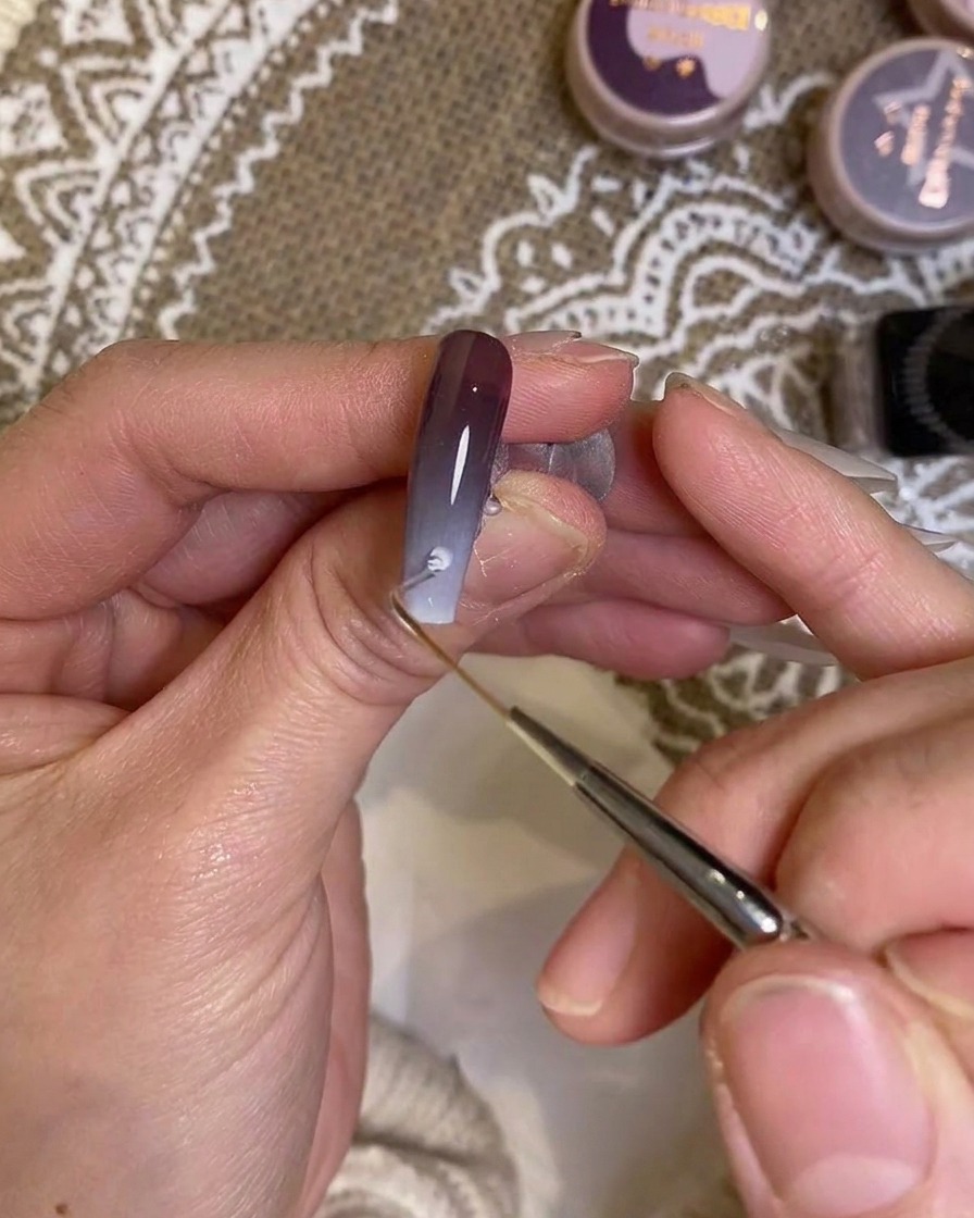 Un pennello di precisione che applica il colore vicino alla zona della cuticola.