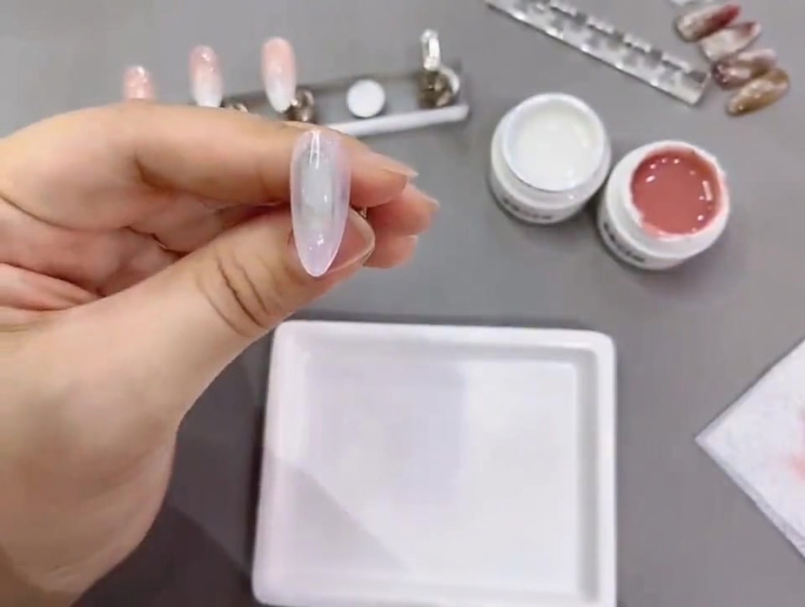 Una punta di unghia in fase di polimerizzazione sotto una lampada UV/LED professionale.