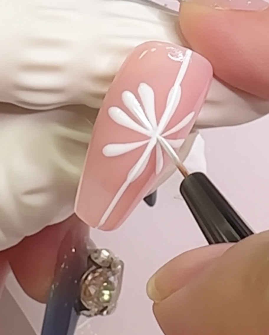 Ununghia che mostra un design a margherita con piccole forme arrotondate dei petali aggiunte alle punte delle linee radiali.
